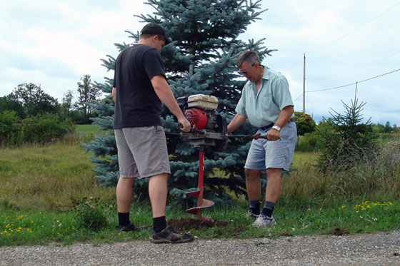 Drilling post holes with an auger