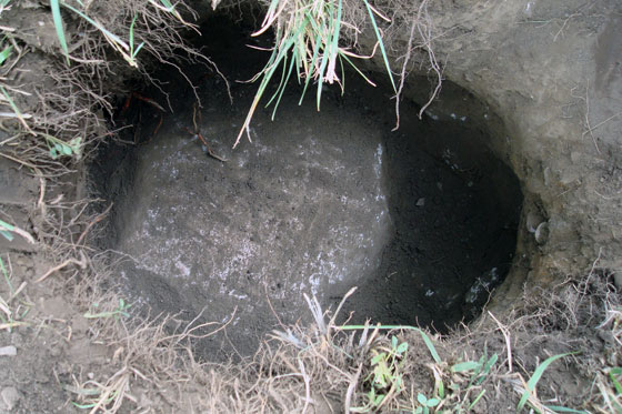 Rock at the bottom of a post hole