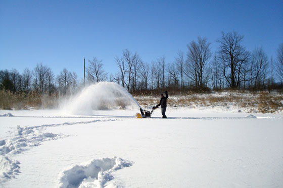 Snow blowing the frozen pond