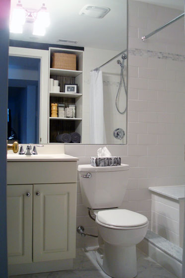 Small basement bathroom with white tile and big mirror