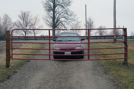 Car behind a closed farm gate