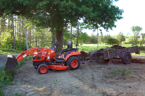 Kioti CS2410 towing a trailer full of manure