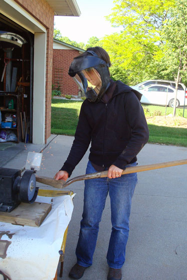 Sharpening a shovel on a grinder