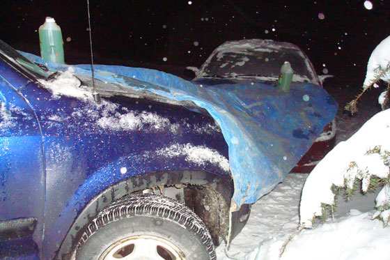 Covering cars with tarps on a cold winter night