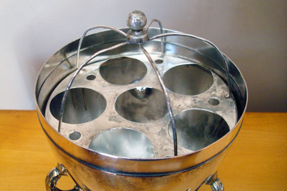 Egg holder inside a silver antique egg coddler