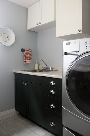 Black and white shaker cabinets with chrome hardware in the laundry room