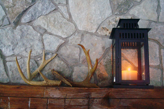 Deer antlers and Ikea Borrby lantern on a barn beam mantel