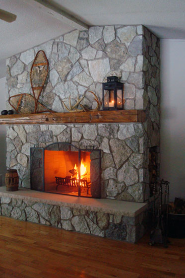 Fieldstone fireplace with barn beam mantel