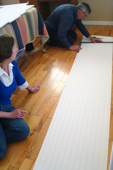 My parents measuring and cutting beadboard wallpaper