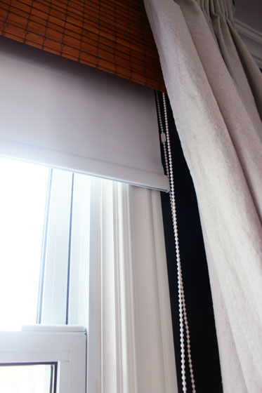 Vinyl blackout blind hidden behind bamboo blinds and dropcloth curtains