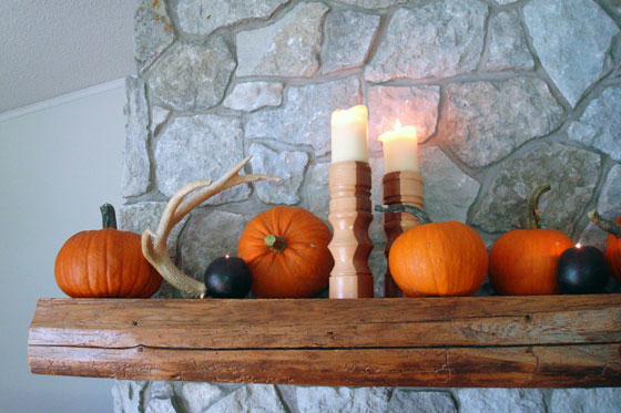 Pumpkins, antlers and candles decorating the mantel