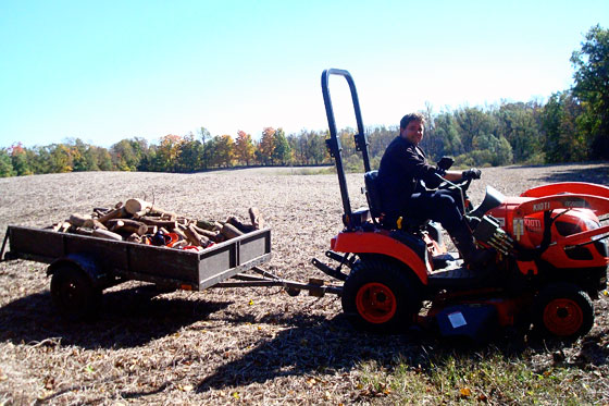 Tractor pulling a trailer full of firewood