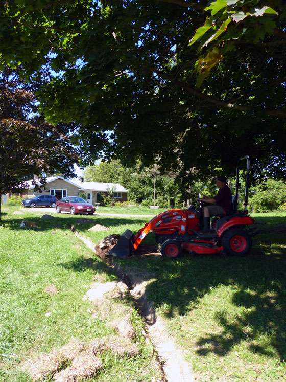 Backfilling the trench with the tractor