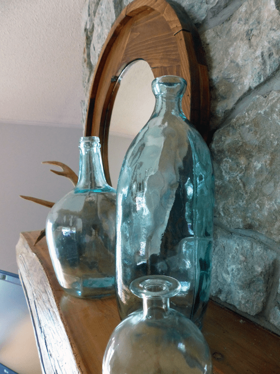 Blue-green glass jugs on the mantel