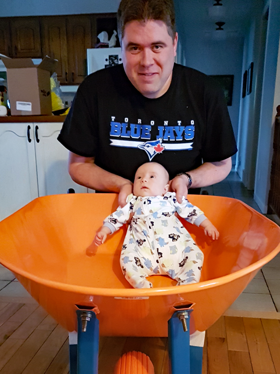 Matt holding Ellie in the wheelbarrow