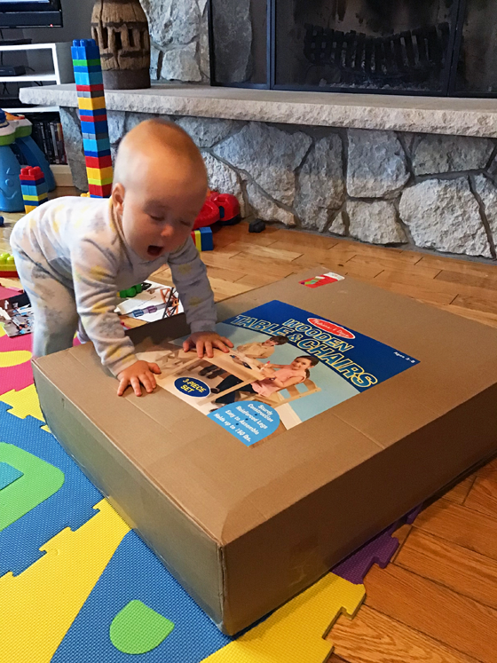 Baby leaning on a box