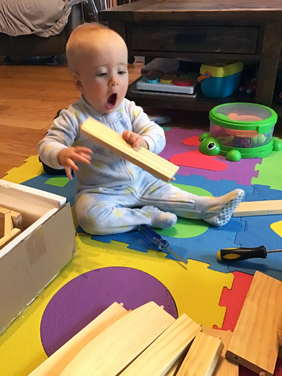 Baby excited to be holding a piece of wood