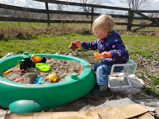 Ellie playing in her sandbox in the garden