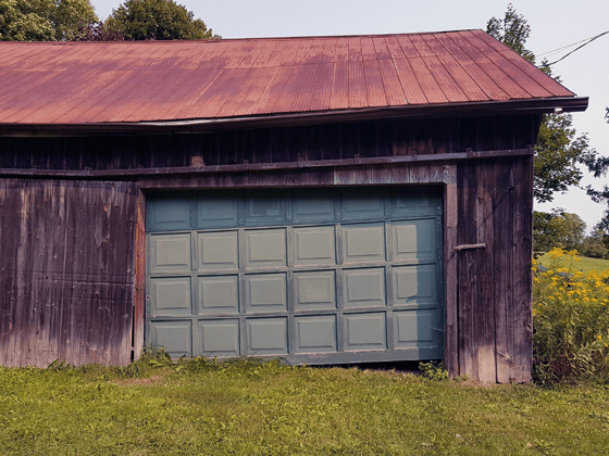 Broken garage door on the small barn