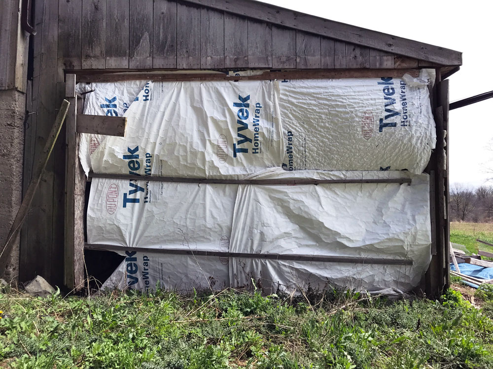 Barn wall covered in white tarp
