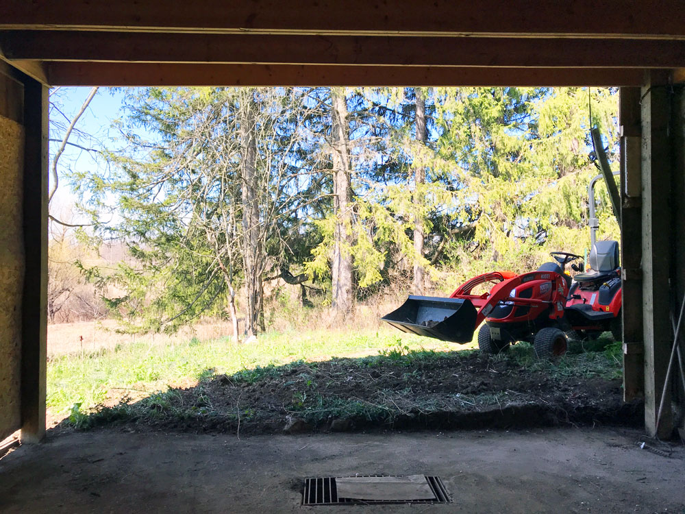 Tractor outside of a large opening in the barn wall
