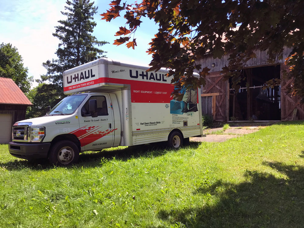 Uhaul truck in front of a barn